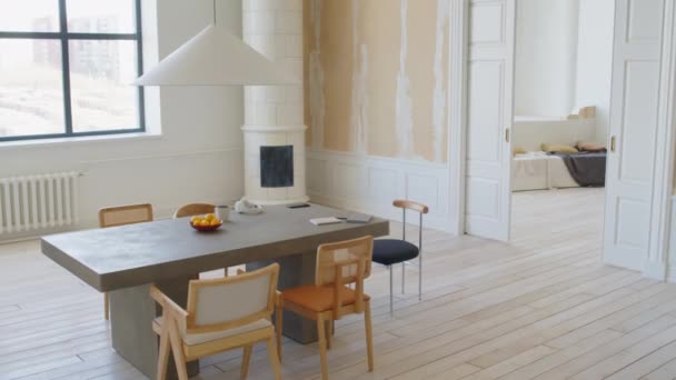 Full shot de sala de estar en el hogar contemporáneo con un diseño minimalista de moda blanco y beige, joven mujer negra en ropa de salón caminando con el ordenador portátil y sentado en la mesa para trabajar - Metraje, vídeo