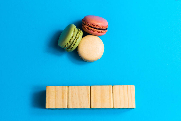Macaron bolo colorido ou macaroon em um fundo azul. Flat lay, vista superior, espaço de cópia - Foto, Imagem