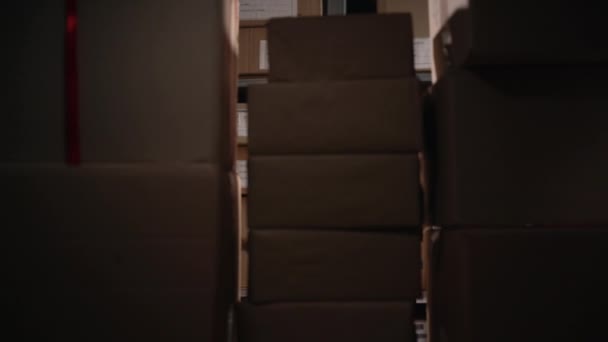 Mujer estresada tratando de atrapar paquetes cayendo en un almacén. Copiar espacio - Metraje, vídeo