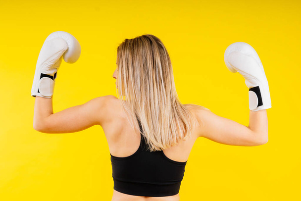 Bojovnice v boxerském studiu. Žena v rukavicích tvrdě trénuje. - Fotografie, Obrázek