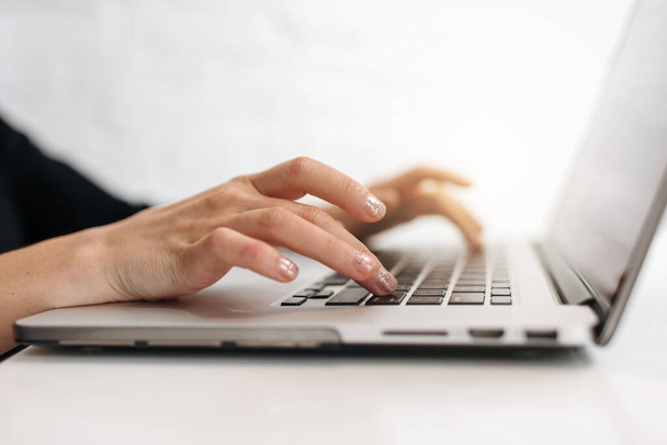 Zamknij kobiecie ręce wpisując klawiaturę na laptopie w biurze. Bizneswoman lub uczennica korzystająca z komputera do marketingu internetowego, freelance, praca w domu, edukacja online, studia na odległość. - Zdjęcie, obraz