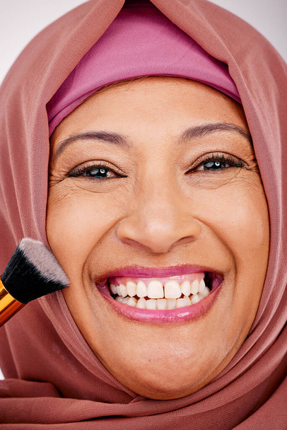 Szczotka do makijażu, uśmiech i portret muzułmanki w studio do rutyny kosmetycznej, naturalnej i twarzy. Szczęśliwy, samodzielny i dojrzały model islamskiej kobiety z narzędziem kosmetologii do leczenia uroku twarzy - Zdjęcie, obraz