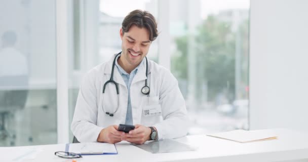 Γιατρός, άνθρωπος και τηλέφωνο στο γραφείο για επικοινωνία, δακτυλογράφηση και συνομιλία με τη σύνδεση δικτύου και χαμόγελο. Επαγγελματική, υγειονομική περίθαλψη και άτομο με smartphone για συνομιλία, ηλεκτρονικό ταχυδρομείο και την τεχνολογία στην εργασία. - Πλάνα, βίντεο