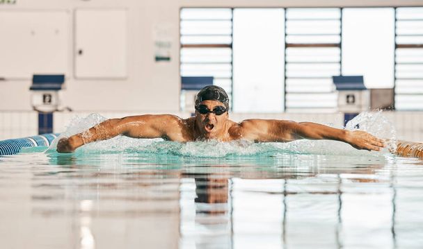 Swimming pool, water splash and sports man challenge, cardio training or butterfly stroke, action and fast motion. Fitness, commitment or swimmer workout, practice or training for competition race. - Photo, Image