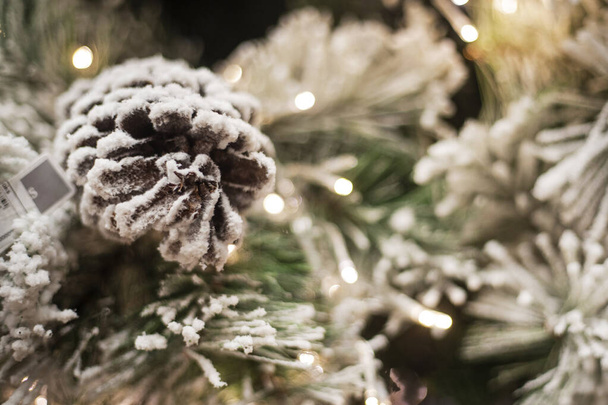 雪で覆われたクリスマスツリーのクリスマスパインコーンからの新年の背景 - 写真・画像