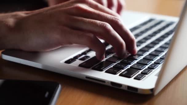 joven trabaja escribiendo en un teclado portátil. Primer plano - Metraje, vídeo