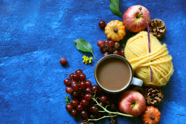 Xícara de café com leite, waffles, maçãs e bolas de chocolate e fios em um fundo azul com espaço de cópia. Conceito de outono acolhedor.  - Foto, Imagem