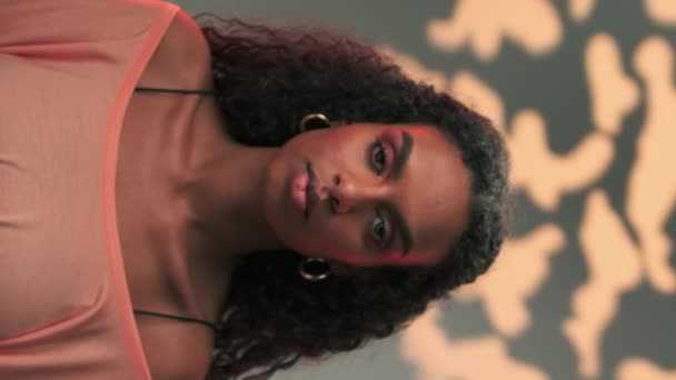 Porträt einer jungen, dunkelhaarigen Frau mit Afro-Frisur und hellem Make-up. Zeitlupe - Filmmaterial, Video