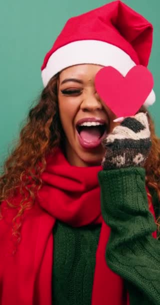 Aranyos fiatal, többnemzetiségű nő játszik szívformákkal, karácsonyi stúdióval. Kiváló minőségű 4k felvételek - Felvétel, videó