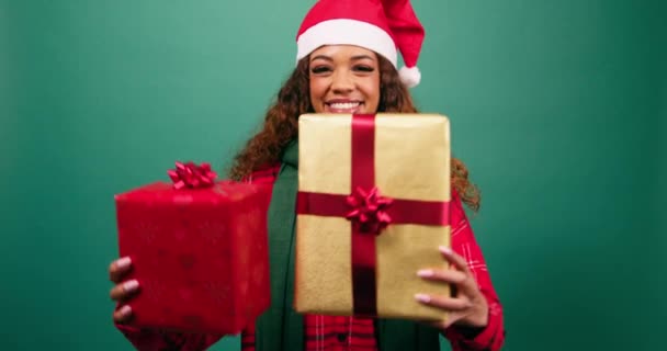 Szczęśliwa młoda kobieta trzyma dwa prezenty świąteczne do kamery, studio. Wysokiej jakości materiał 4k - Materiał filmowy, wideo