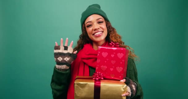 Mooie jonge vrouw groet, zwaait hallo en overhandigt verpakt kerstcadeau. Hoge kwaliteit 4k beeldmateriaal - Video