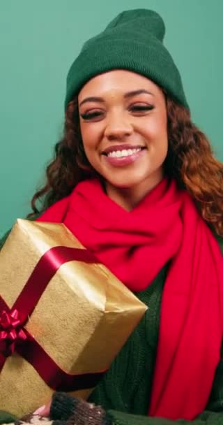 Güzel genç bir kadın selamlar, selamlar ve paketlenmiş Noel hediyesini verir. Yüksek kalite 4k görüntü - Video, Çekim
