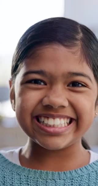 Selfie, gezicht en lachen met een meisje kind close-up in de woonkamer van haar huis voor speelse opname. Portret, glimlach en gelukkig jong Indiaas kind in haar huis voor een video, film of film voor de jeugd. - Video