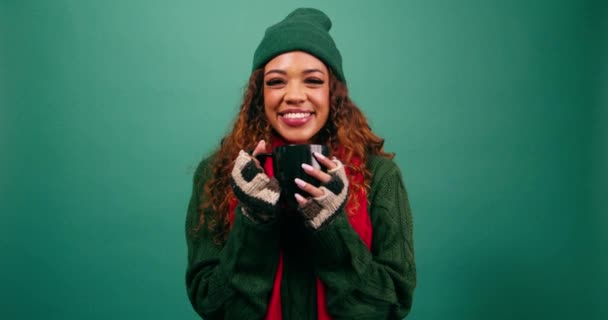 Kaunis nuori nainen hymyilee ja pitää lämpimän juoman, joulun viihtyisä teema. Laadukas 4k kuvamateriaalia - Materiaali, video