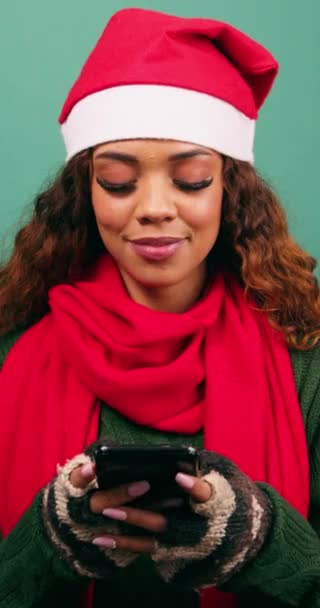 Mujer joven mira a la cámara y sonríe, mensajes de texto amigos durante la Navidad, estudio. Imágenes de alta calidad 4k - Metraje, vídeo