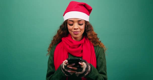 Mujer joven mira a la cámara y sonríe, mensajes de texto amigos durante la Navidad, estudio. Imágenes de alta calidad 4k - Metraje, vídeo