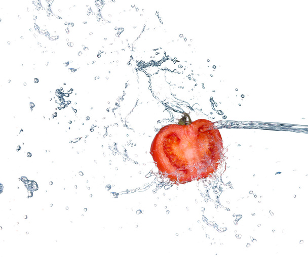 Tomate en spray d'eau. Tomate juteuse avec éclaboussure sur fond blanc
 - Photo, image