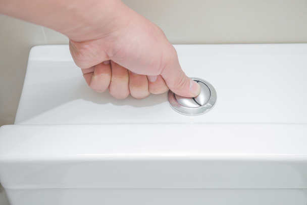 pushing a button to flush a closestool - Foto, Bild