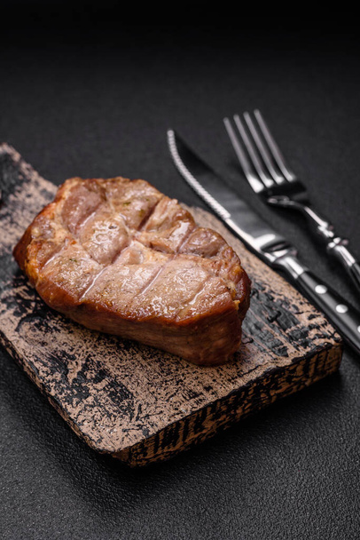 Смачний соковитий свинячий або яловичий стейк, приготований на грилі з сіллю та спеціями на текстурованому бетонному фоні - Фото, зображення