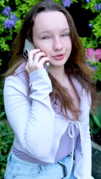Νεαρή γοητευτική γυναίκα καλώντας με κινητό τηλέφωνο, ενώ κάθεται μόνη της στην καφετέρια κατά τη διάρκεια του ελεύθερου χρόνου, ελκυστική γυναίκα με χαριτωμένο χαμόγελο μιλώντας συνομιλία με το κινητό τηλέφωνο, ενώ. - Πλάνα, βίντεο