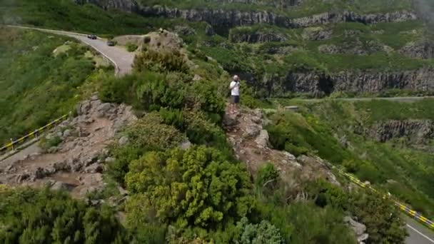 Madeira, Portugal - 2023.04.04 - 09: Άντρας με μια κάμερα να στέκεται στην κορυφή του βράχου στο Lombo do Mouro άποψη την ηλιόλουστη μέρα - Πλάνα, βίντεο