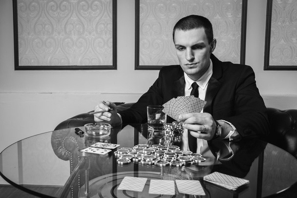 Mies pelaa pokeria pokeripöydässä
 - Valokuva, kuva