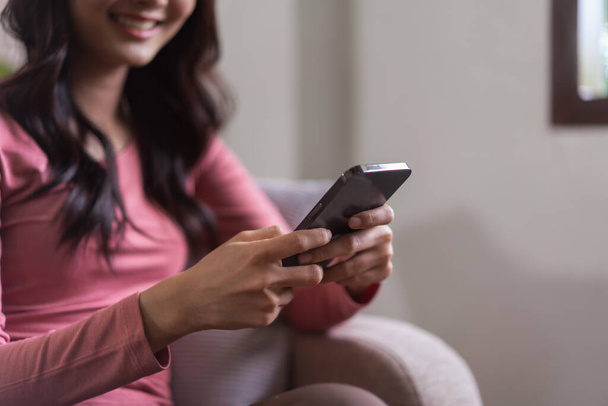 Las mujeres de ocio en el sofá y el uso de teléfonos inteligentes para navegar por las redes sociales y el chat en el estilo de vida en casa. - Foto, Imagen