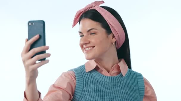 Selfie, segno di moda e pace con una donna di social media in studio su sfondo blu per una foto del profilo. Telefono, sorriso e un giovane influencer felice o creatore di contenuti in posa per un aggiornamento di stato. - Filmati, video
