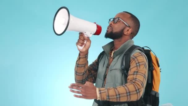 Megafone, falando e um homem negro em um fundo azul para viagens, caminhadas ou camping anúncio. Discurso, comunicação e uma pessoa africana ou turista com um alto-falante para conversa e voz. - Filmagem, Vídeo