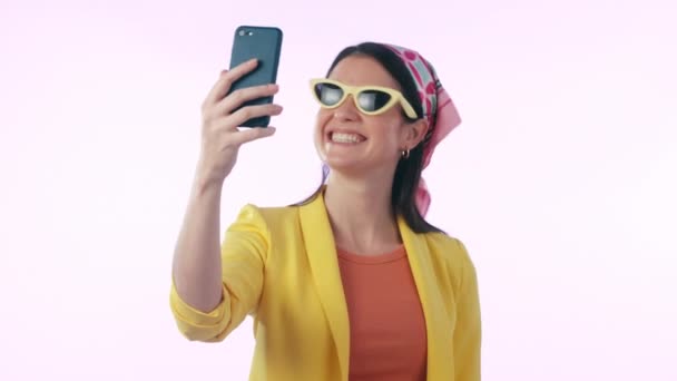 Selfie, sourire et signe de paix avec une femme des médias sociaux en studio sur fond bleu pour une photo de profil. Téléphone, sourire et drôle de photo avec un jeune influenceur heureux posant pour une mise à jour de statut. - Séquence, vidéo