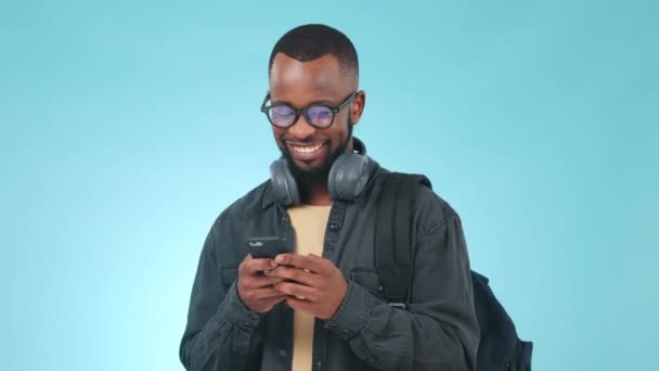 Phone, man and happiness in studio for social media, funny meme or text message in studio on blue background. Smartphone, person and smile for internet gif, website search or online post with mockup. - Footage, Video