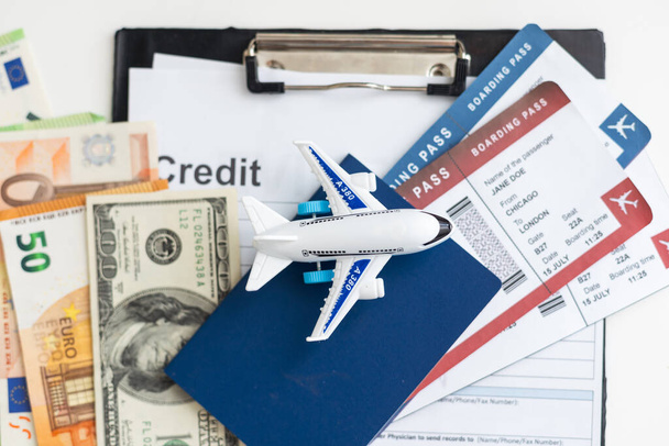 Vliegtickets, paspoorten, geld en speelgoedvliegtuig op tafel. Hoge kwaliteit foto - Foto, afbeelding