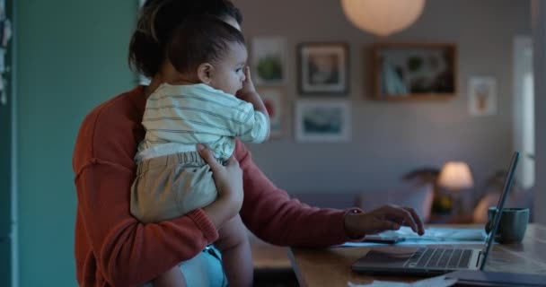 Φορητός υπολογιστής, τηλεργασία ή multitask με μητέρα και μωρό στο σπίτι τους το βράδυ για υπερωρίες. Υπολογιστής, οικογένεια και επιχειρηματίας που εργάζεται στην κουζίνα με το βρέφος παιδί της ως μονογονέας. - Πλάνα, βίντεο