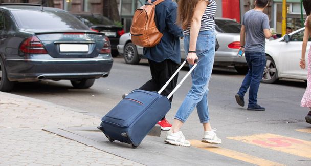 Chica con equipaje en una calle de la ciudad. Viajar. Vacaciones - Foto, Imagen