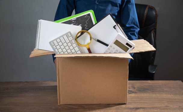 Businessman with a cardboard box and business objects. Job loss. Unemployment - Photo, Image