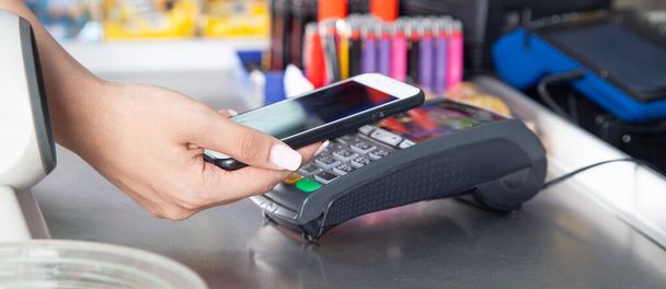 Customer paying for purchases contactless with smartphone. - Photo, Image