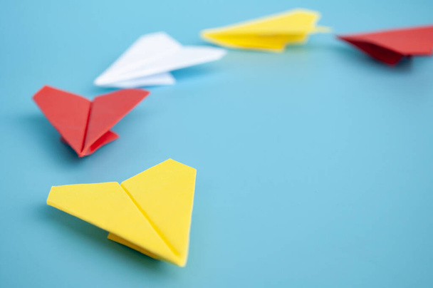 Keltainen paperi kone origami johtava muut paperi lentokoneita sinisellä pohjalla. Johtamisen käsite. - Valokuva, kuva