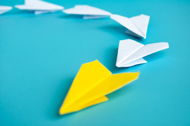 Χαμηλή άποψη του κίτρινο αεροπλάνο από χαρτί origami οδηγεί λευκά αεροπλάνα χαρτί. Με χώρο αντιγραφής για κείμενο - Φωτογραφία, εικόνα