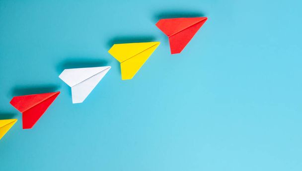 Vista superior del origami de avión de papel rojo que lidera otros aviones de papel. Con espacio de copia para texto. - Foto, imagen