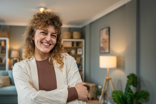 Egy felnőtt kaukázusi nő portréja otthon boldog mosoly göndör haj - Fotó, kép