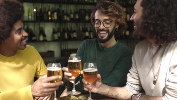 Счастливые многорасовые друзья пьют пиво в пивоварне. Разнообразные молодые люди празднуют вместе болеть за напитки в ирландском пабе, наслаждаясь счастливым часом.  - Кадры, видео