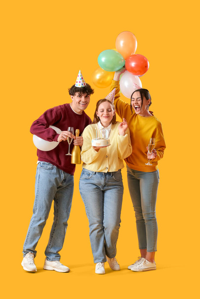 Young friends celebrating Birthday on yellow background - Photo, image