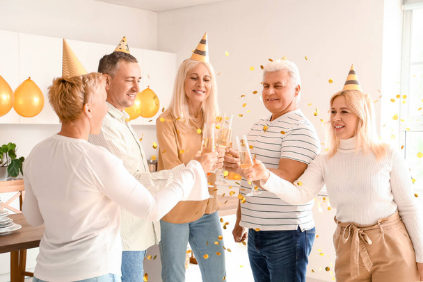 Kypsät ihmiset juovat samppanjaa syntymäpäiväjuhlissa keittiössä - Valokuva, kuva