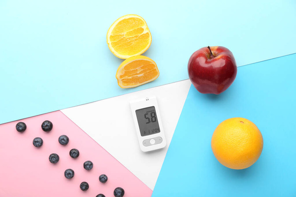 Glucometer with food on color background. Diabetes concept - Photo, Image