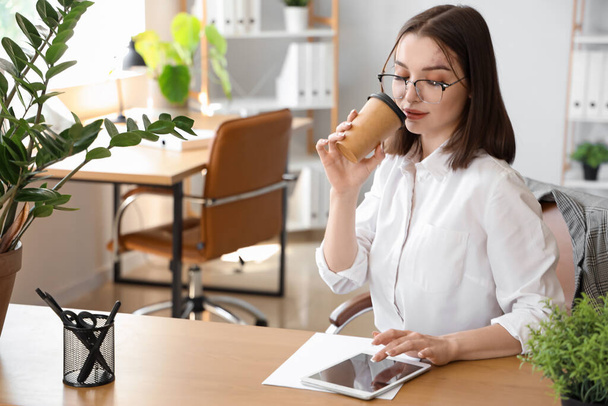 Jovem empresária com xícara de café trabalhando no escritório - Foto, Imagem