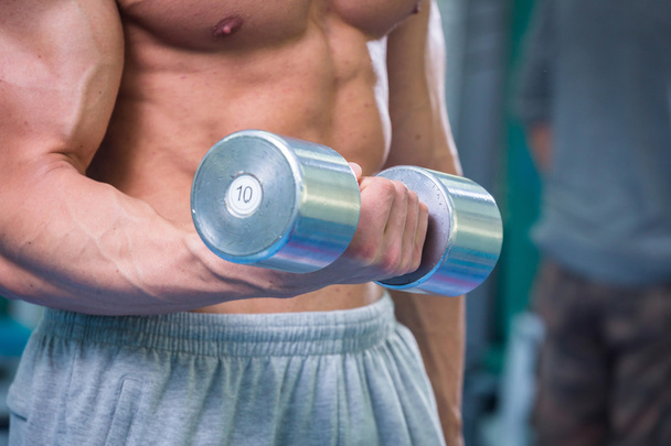 Muscular man working out with dumbbells - Photo, Image