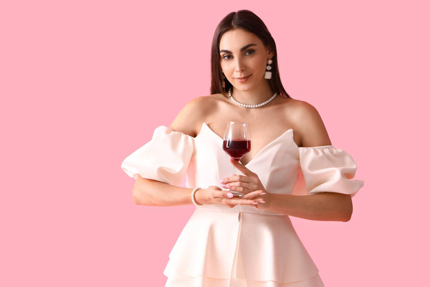 fiatal nő üveg bor rózsaszín háttér - Fotó, kép