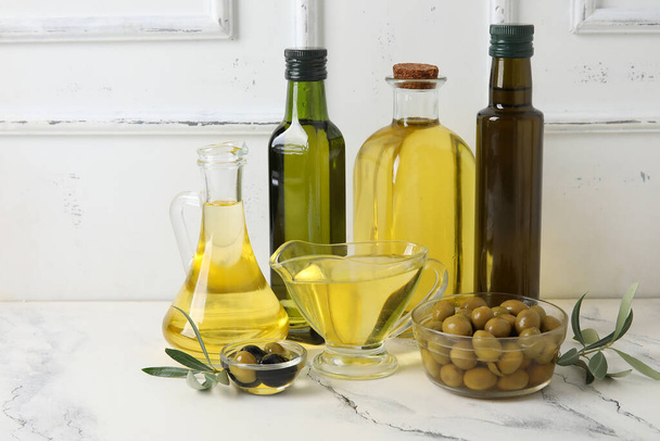 Různé skleněné zboží z čerstvého olivového oleje na stole - Fotografie, Obrázek