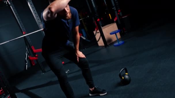 muotokuva väsynyt urheilija kuntosalilla harjoittelun jälkeen mies pyyhkii hikeä otsastaan kädellään - Materiaali, video