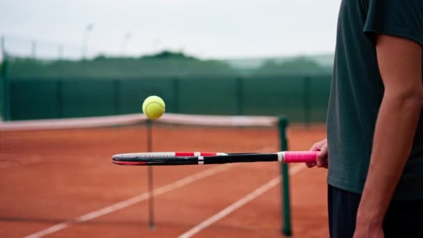 primer plano joven entrenador de tenis golpeando la pelota con una raqueta en la cancha de tenis preparándose para el estilo de vida deportivo de la competencia - Imágenes, Vídeo